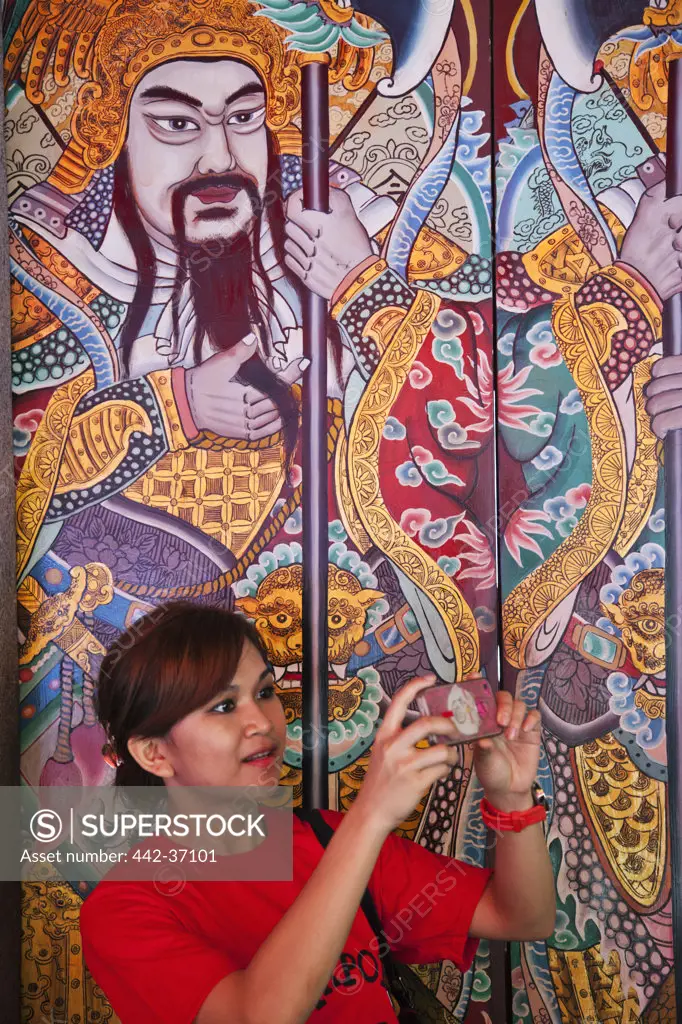 Woman taking picture at a temple, Thian Hock Keng Temple, Chinatown, Singapore