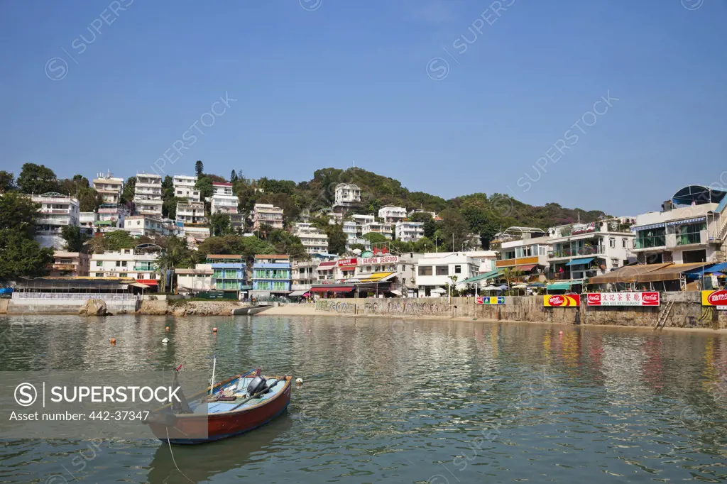 Boat with a town at the waterfront, Yung Shue Wan, Lamma Island, Hong Kong, China