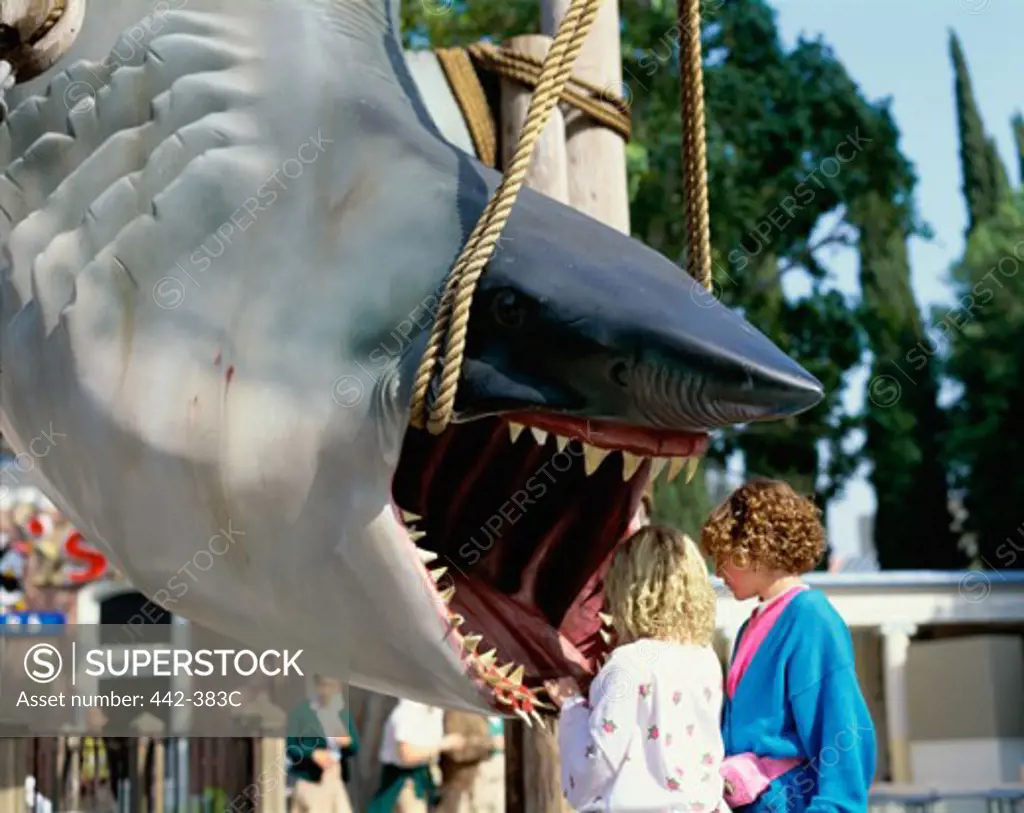 Children looking into the mouth of an artificial shark at Universal Studios Hollywood, Los Angeles, California, USA