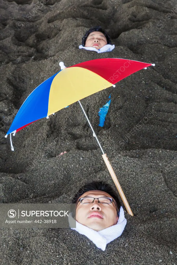 Japan, Kyushu, Kagoshima, Ibusuki, Thermal Sand Baths, Men Relaxing in Sand
