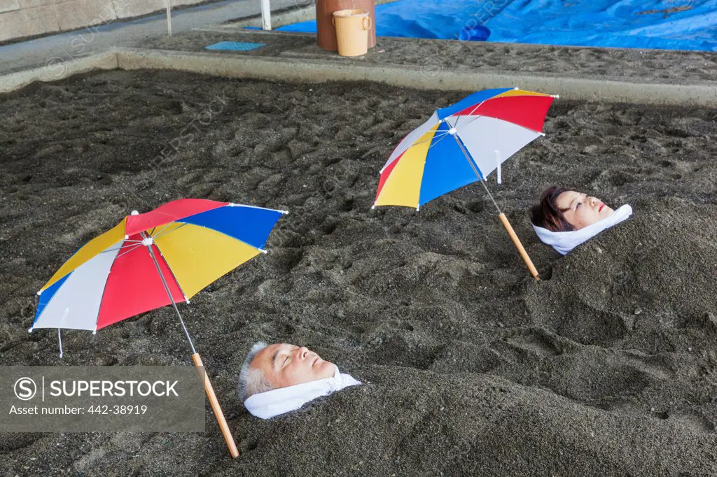 Japan, Kyushu, Kagoshima, Ibusuki, Thermal Sand Baths, Man and Woman Relaxing in Sand