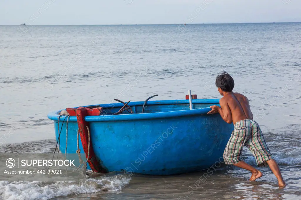 Vietnam, Mui Ne, Mui Ne Beach, Fisherman Launching Coracle Fishing Boat