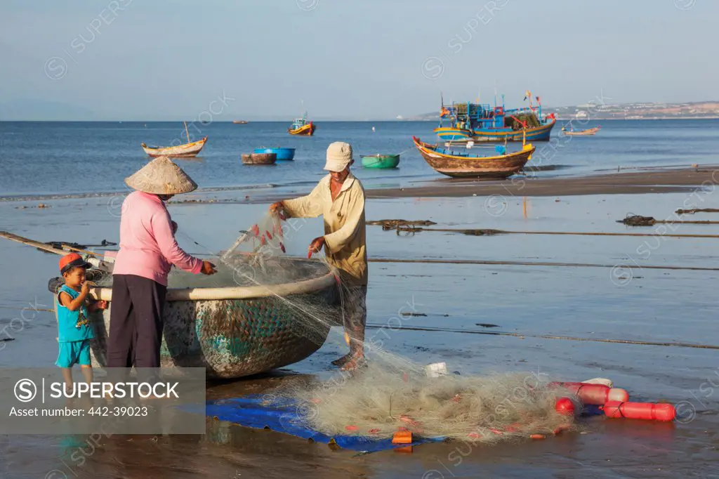 Vietnam, Mui Ne, Mui Ne Beach, Fishermen with Coracle Fishing Boat