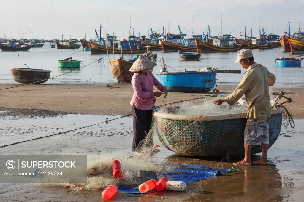 Vietnam, Mui Ne, Mui Ne Beach, Fishermen with Coracle Fishing Boat