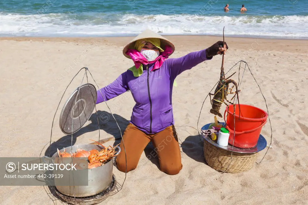 Vietnam, Nha Trang, Nha Trang Beach, Woman selling crabs and lobsters on beach