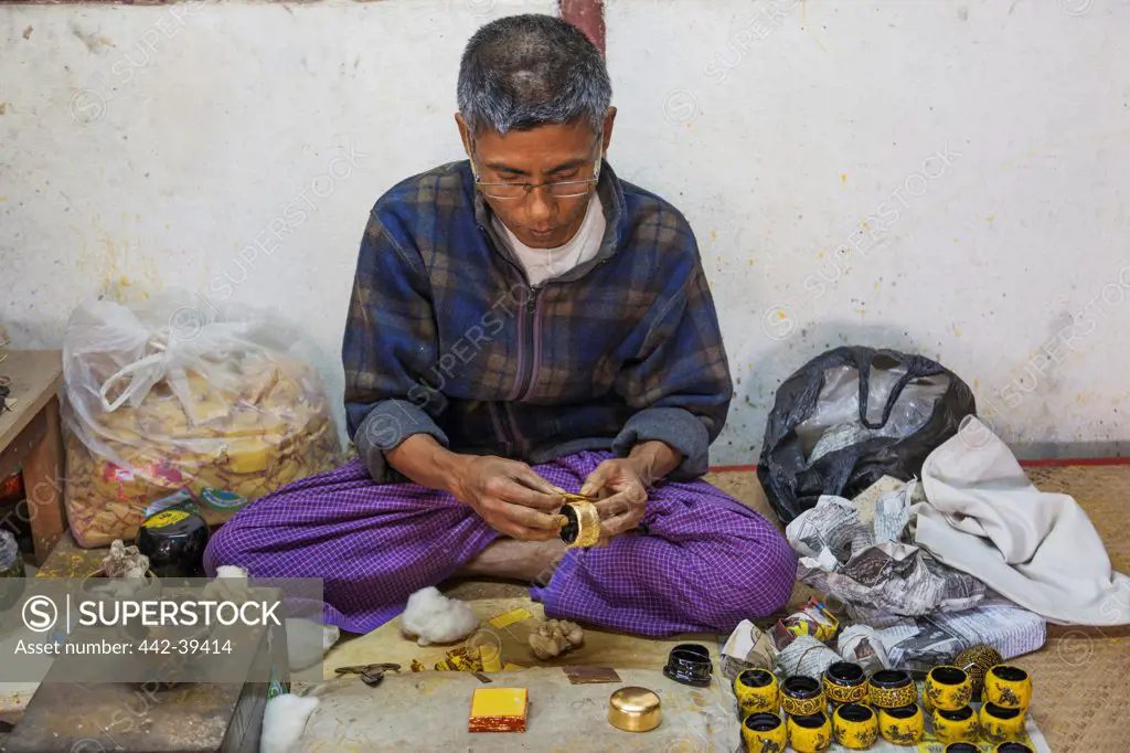 Lacquerware maker applying gold leaf, Bagan, Myanmar