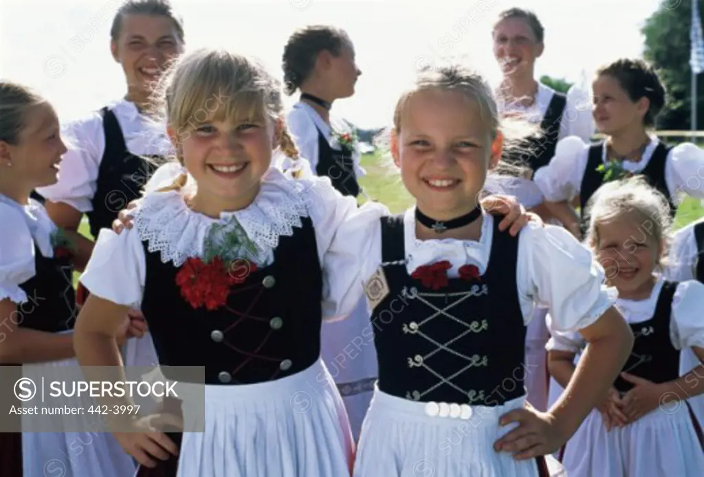 Girls standing and smiling in a Bavarian festival, Rosenheim, Germany