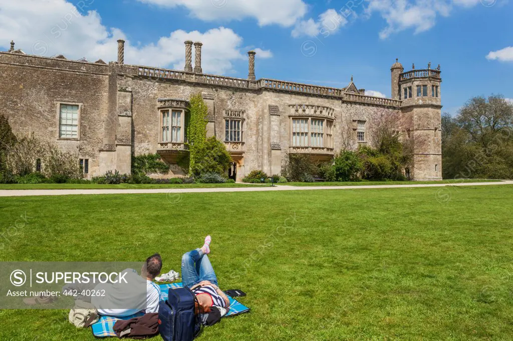 UK, England, Somerset, Lacock, Lacock Abbey, Tourists resting on lawn