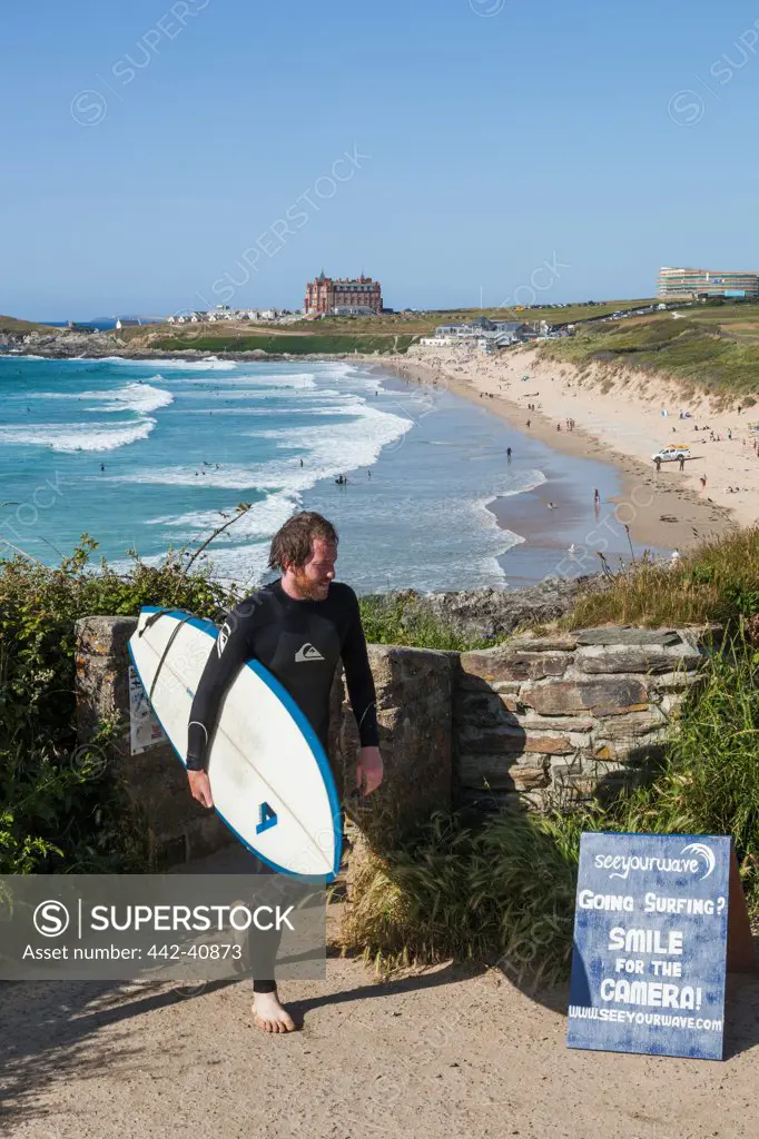 Surfer with surfboard on the beach, Fistral Beach, Newquay, Cornwall, England