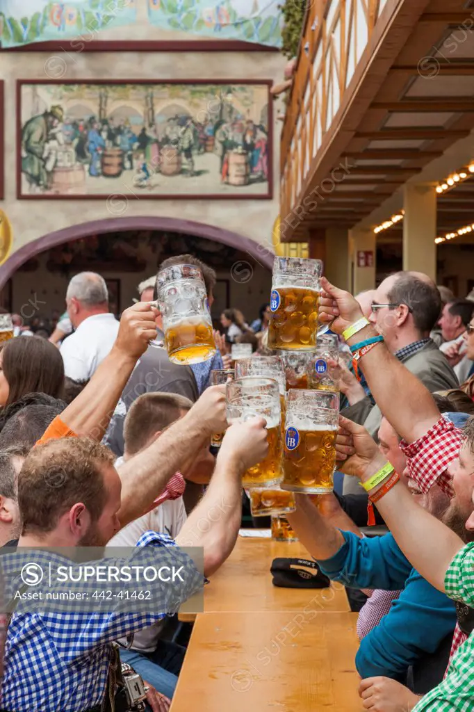 Group of people enjoying beer in Oktoberfest festival, Munich, Bavaria, Germany