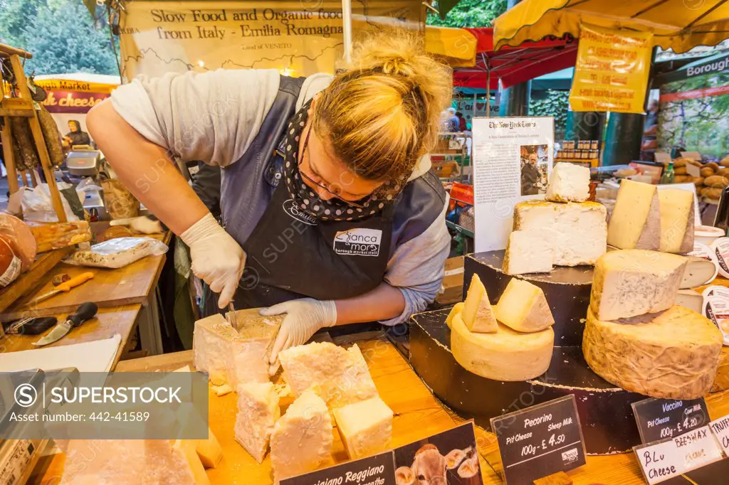Seller at cheese stall, Borough Market, Southwark, London, England