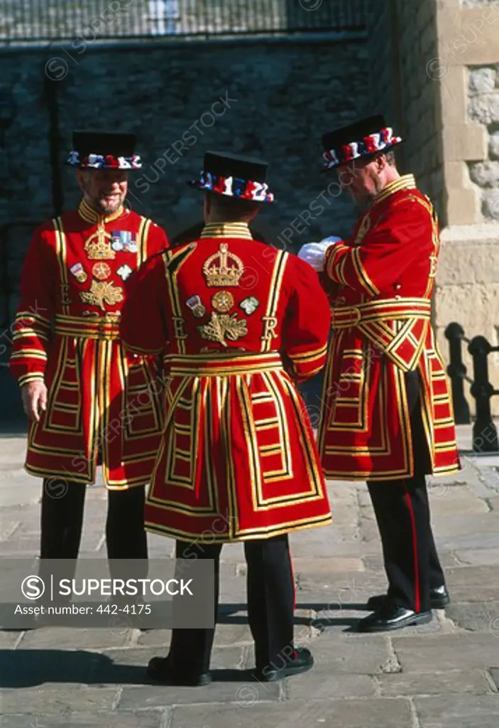 Three Beefeaters standing at a gate, Tower of London, London, England