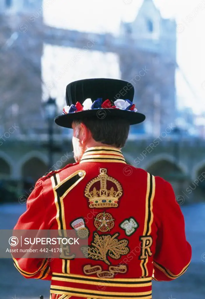 Rear view of a Beefeater with a bridge in the background, Tower Bridge, London, England