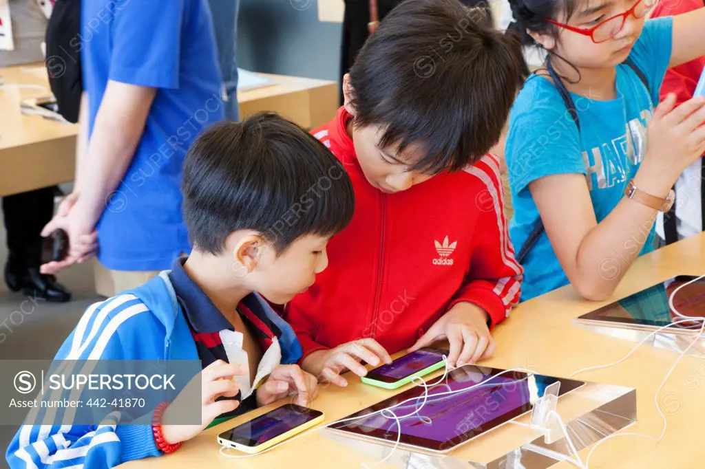 China, Hong Kong, Apple Store, Children Looking at smartphone