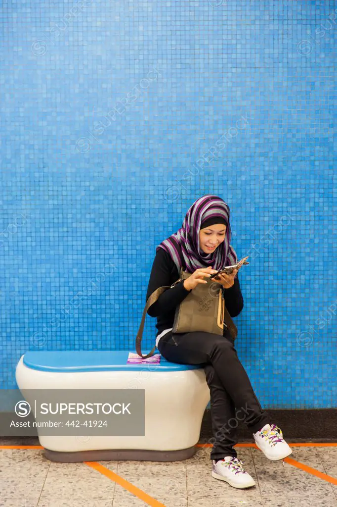 China, Hong Kong, Muslim Girl Using Smartphone