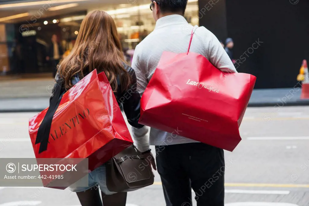 China, Hong Kong, Central District, Couple Carrying Valentino and Lane Crawford Shopping Bags