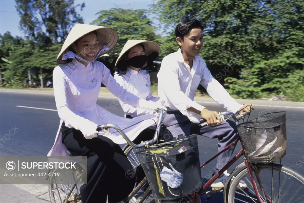 Three people cycling, Can Tho, Vietnam