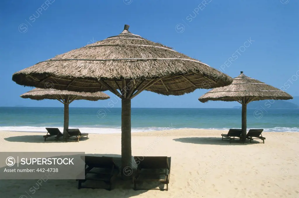 Lounge chairs under sunshades on the beach, Nha Trang Beach, Nha Trang, Vietnam