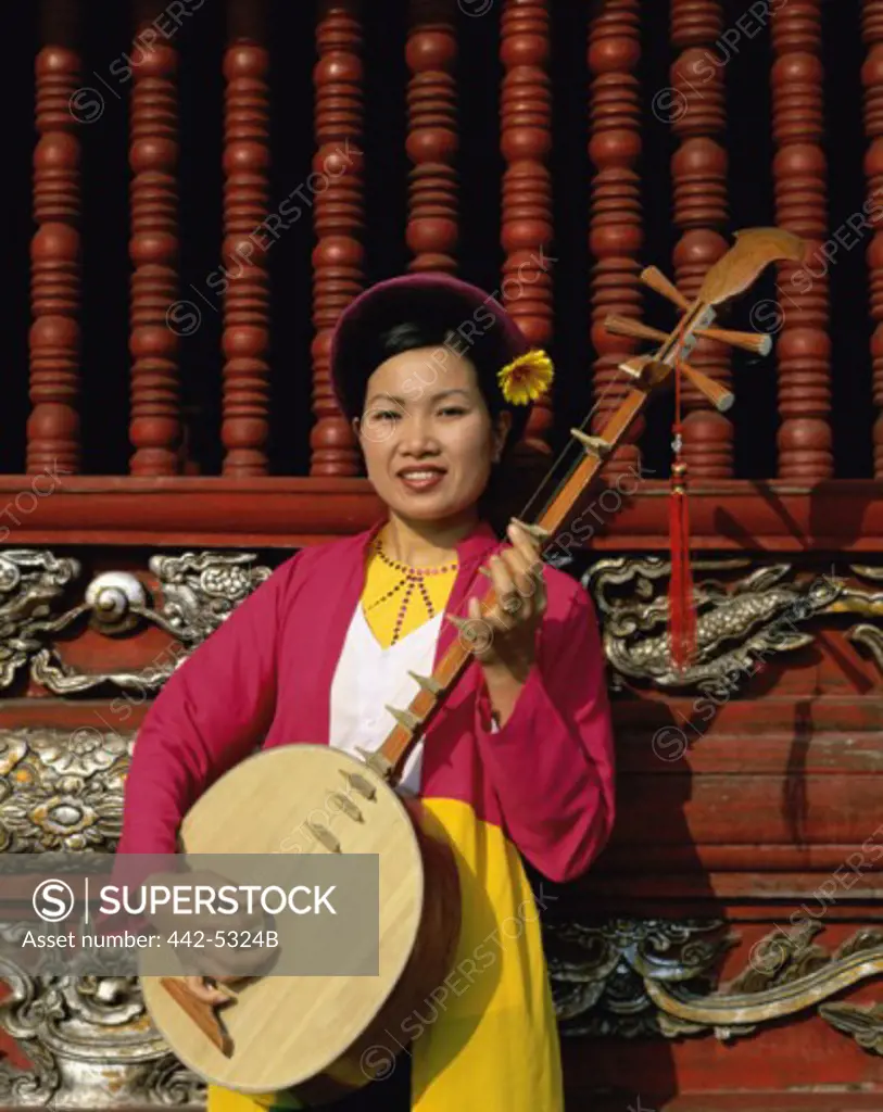 Young woman playing a bamboo instrument, Temple of Literature, Hanoi, Vietnam