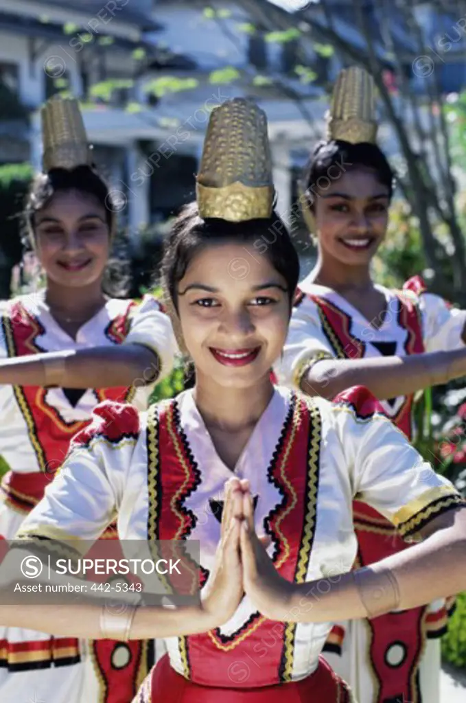 Portrait of three young women dressed in traditional dancing costumes, Kandy, Sri Lanka