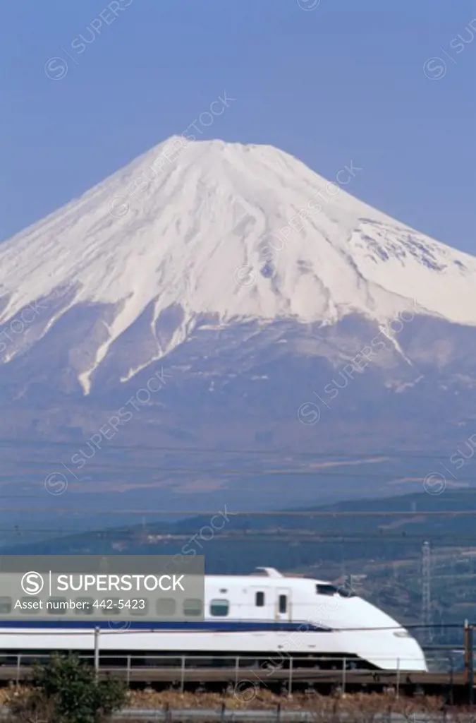Side profile of a bullet train with a mountain in the background, Mount Fuji, Japan