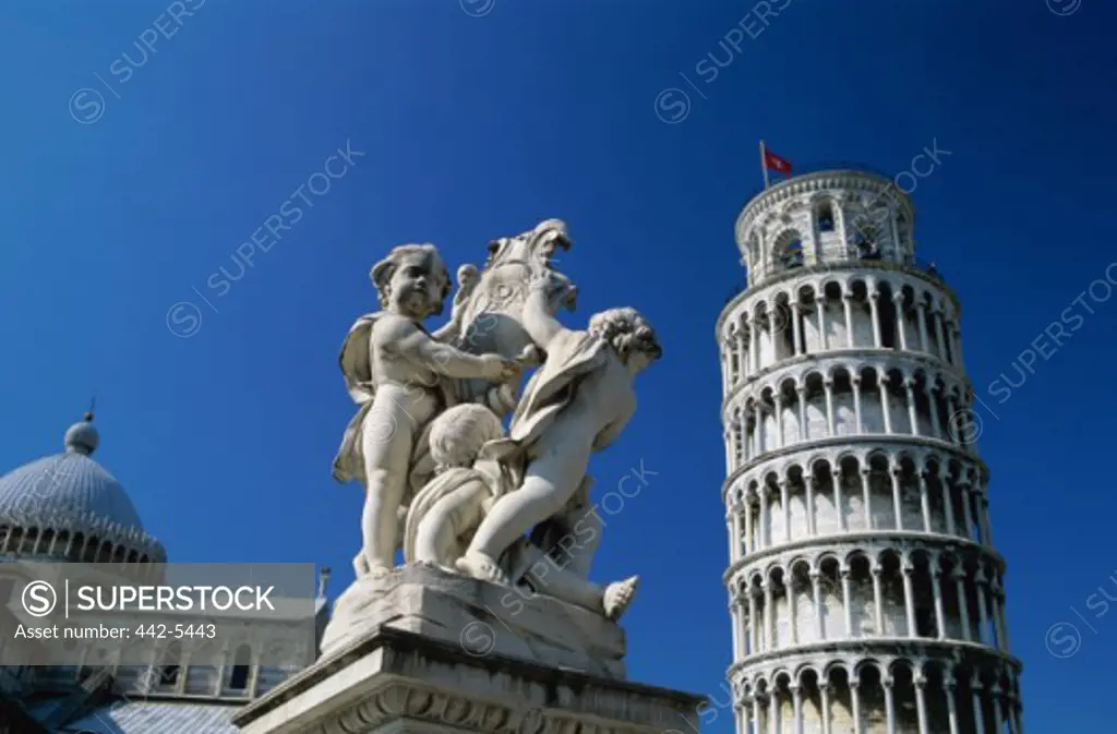Low angle view of a statue in front of the Leaning Tower, Pisa, Italy