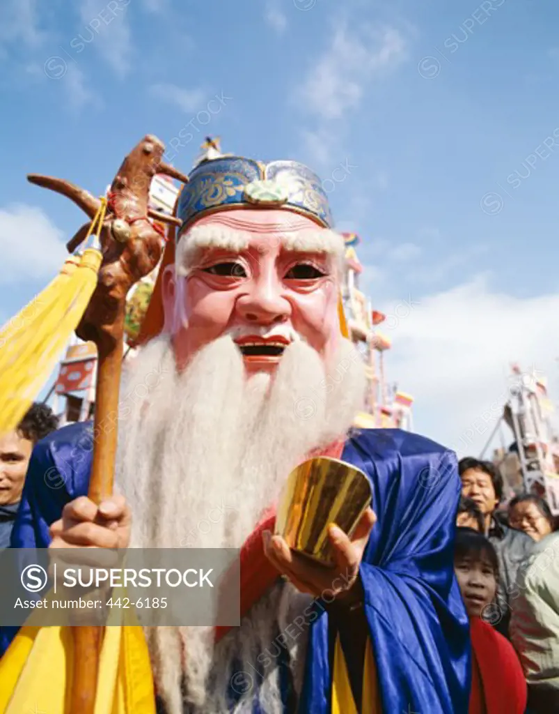 Person wearing a Chinese Lucky God Mask, God of Longevity, Shanghai, China