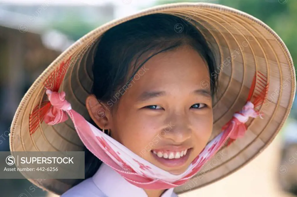 Portrait of a teenage girl wearing a traditional conical hat, Ho Chi Minh City, Vietnam