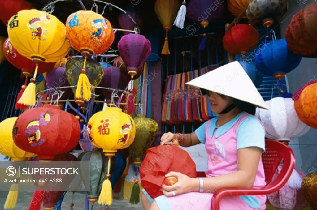 Teenage girl making lanterns in a shop, Hoi An, Vietnam