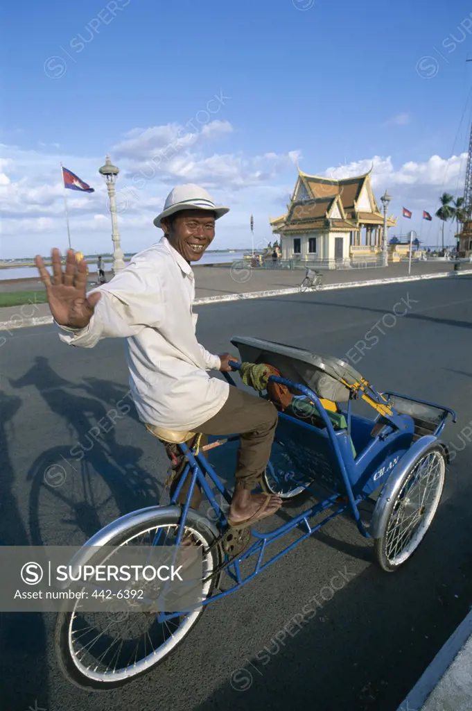 Portrait of a rickshaw driver waving, Phnom Penh, Cambodia