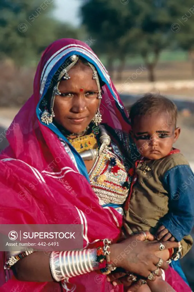 Mid adult woman carrying her son, Rajasthan, India