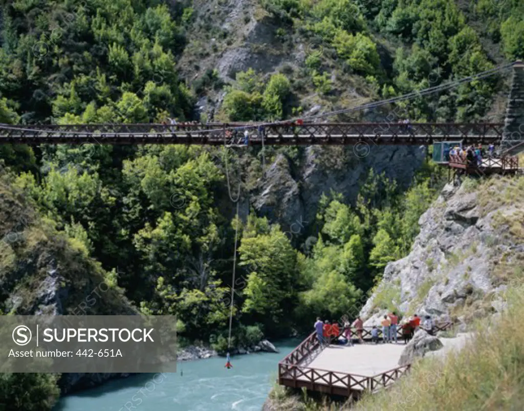 High angle view of tourists looking at a bungee jumper jumping from a bridge, Queenstown, New Zealand