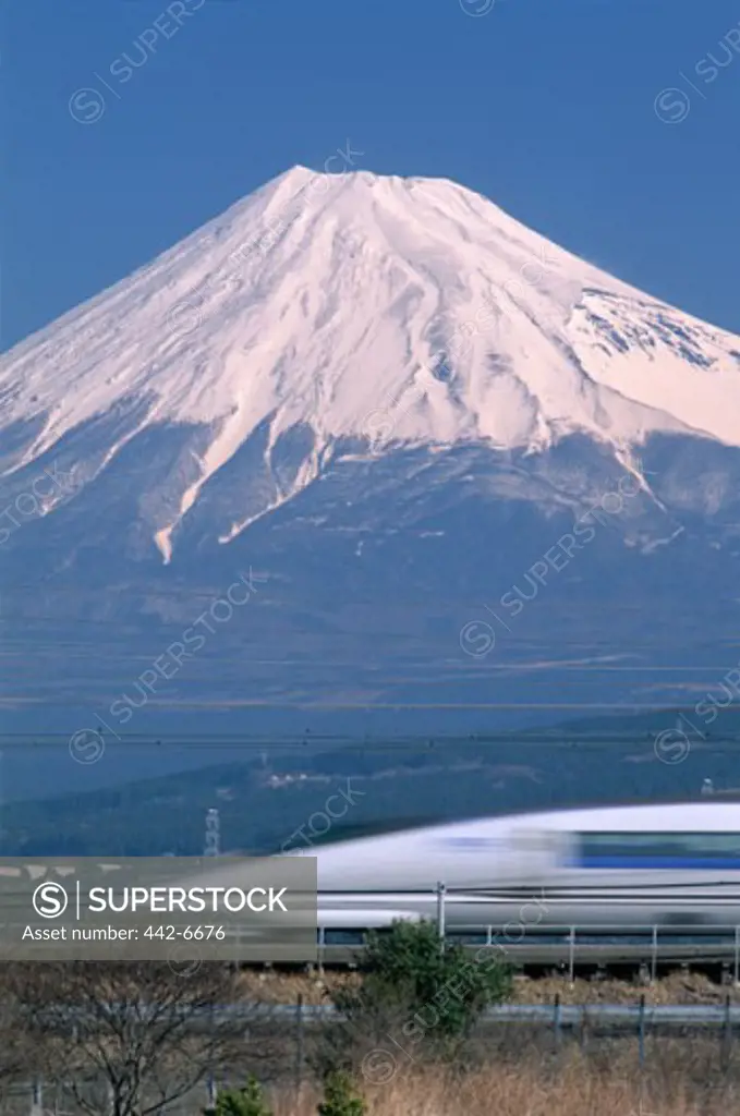 Bullet train passing by a mountain, Mount Fuji, Honshu, Japan