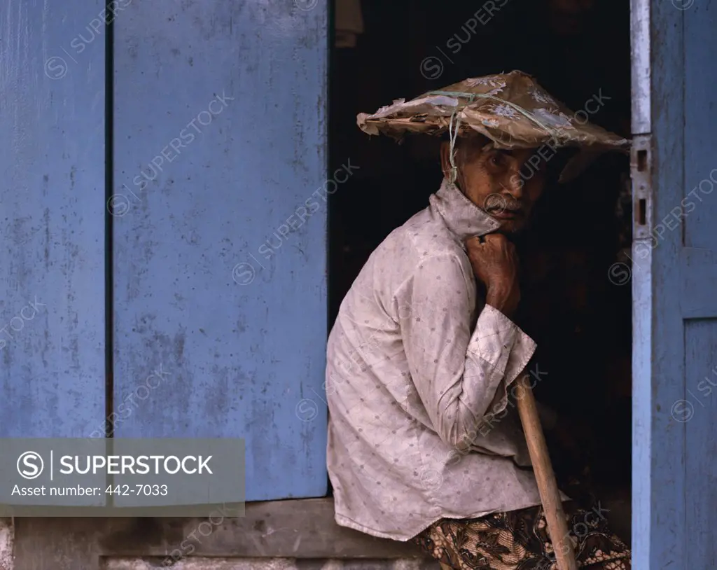 Portrait of a senior man sitting on a doorstep, Bali, Indonesia