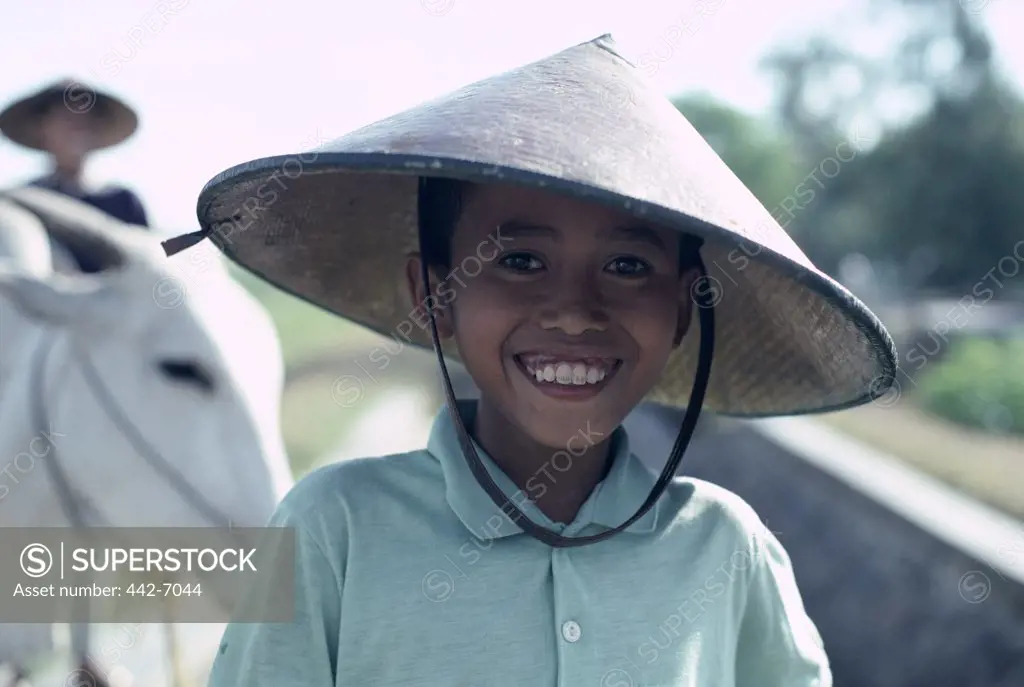 Portrait of a boy wearing a conical hat, Java, Indonesia