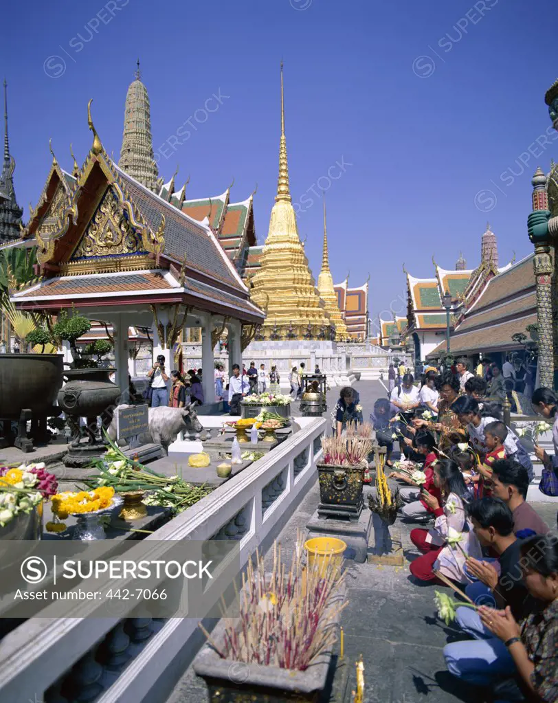 People praying in a temple, Wat Phra Kaeo (Temple of the Emerald Buddha), Bangkok, Thailand