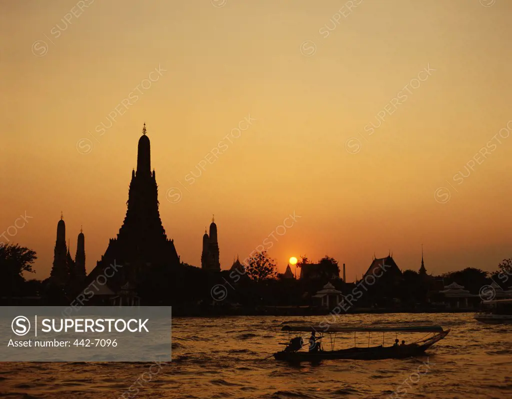 Sunset over a temple, Wat Arun, Chao Phraya River, Bangkok, Thailand
