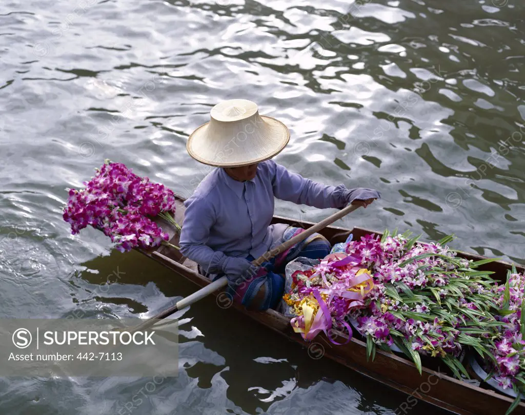 Female vendor in a boat selling flowers, Floating Market, Damnoen Saduak, Bangkok, Thailand
