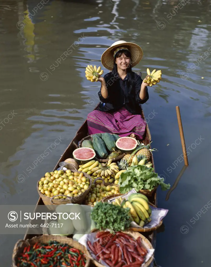 Female vendor in a boat selling fruit, Floating Market, Damnoen Saduak, Bangkok, Thailand