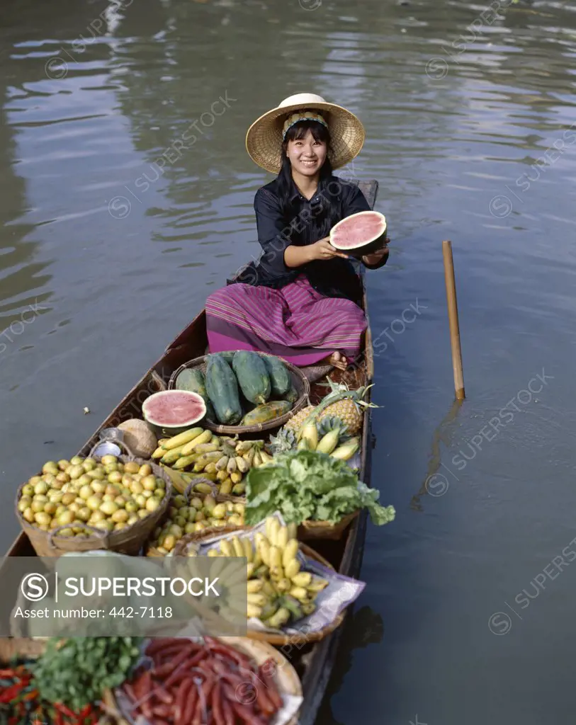 Female vendor in a boat selling fruit, Floating Market, Damnoen Saduak, Bangkok, Thailand