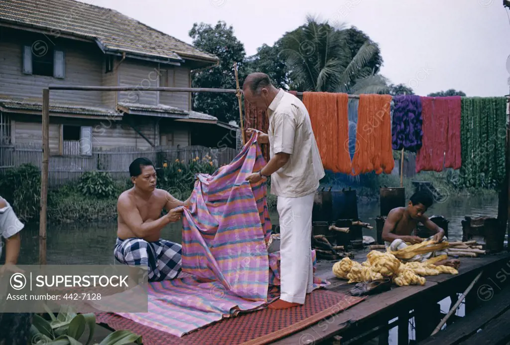 Man inspecting a silk cloth, Thai Silk, Bangkok, Thailand