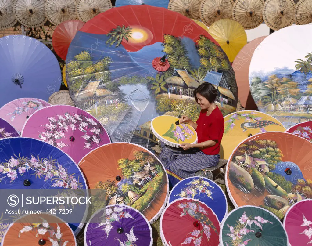 Side profile of a young woman painting parasols, Bo Sang, Chiang Mai, Golden Triangle, Thailand