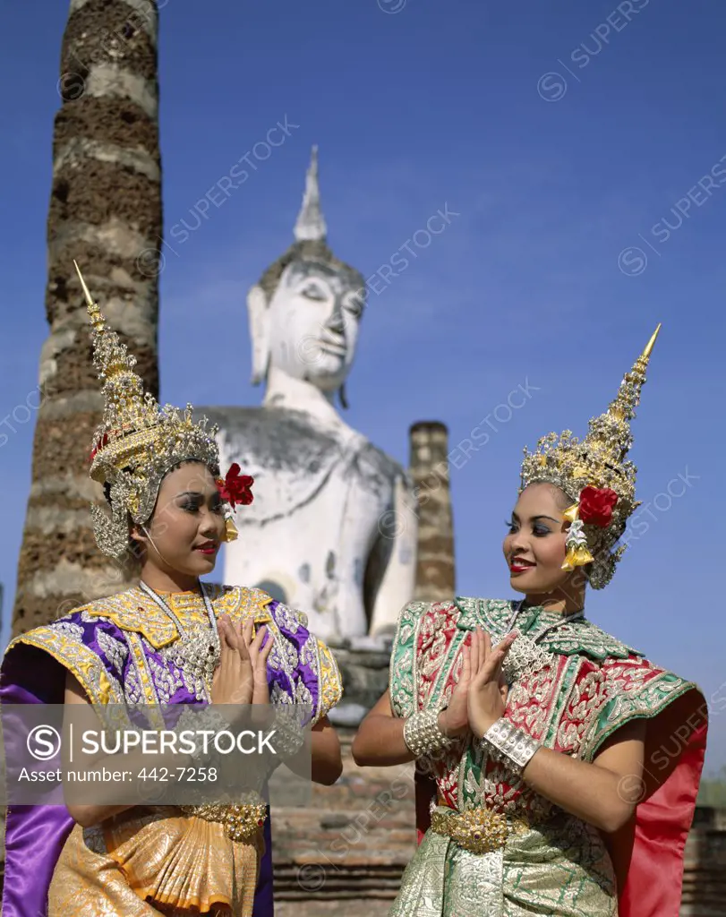 Two female dancers dressed in traditional dancing costumes at a temple, Wat Mahathat, Sukhothai, Thailand