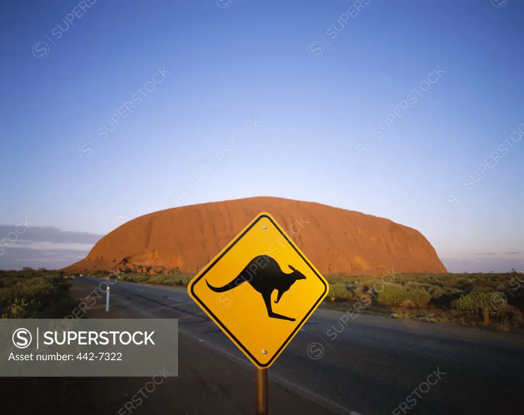 Kangaroo sign on a road with a rock formation in the background, Ayers Rock, Uluru-Kata Tjuta National Park, Northern Territory, Australia