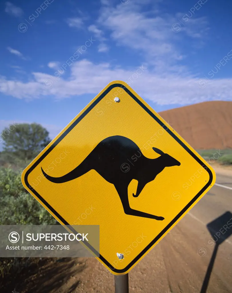 Kangaroo sign on a road with a rock formation in the background, Ayers Rock, Uluru-Kata Tjuta National Park, Northern Territory, Australia