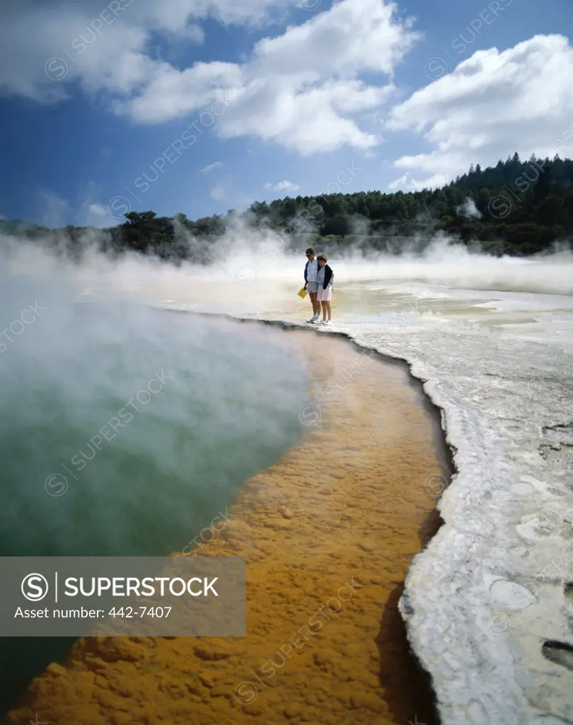 Two people standing at a thermal pool, Champagne Pool, Waiotapu Thermal Area, Rotorua, New Zealand