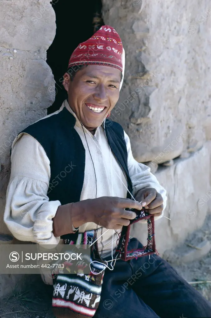 Portrait of mature man knitting, Lake Titicaca, Taquile Island, Peru