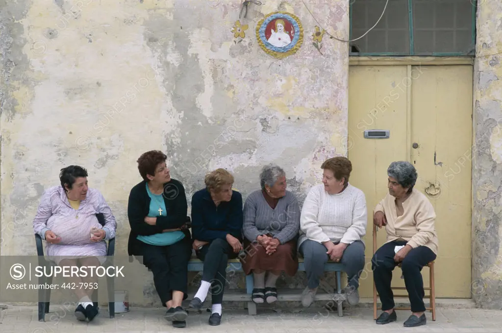 Group of women sitting together talking, Marsaxlokk, Malta