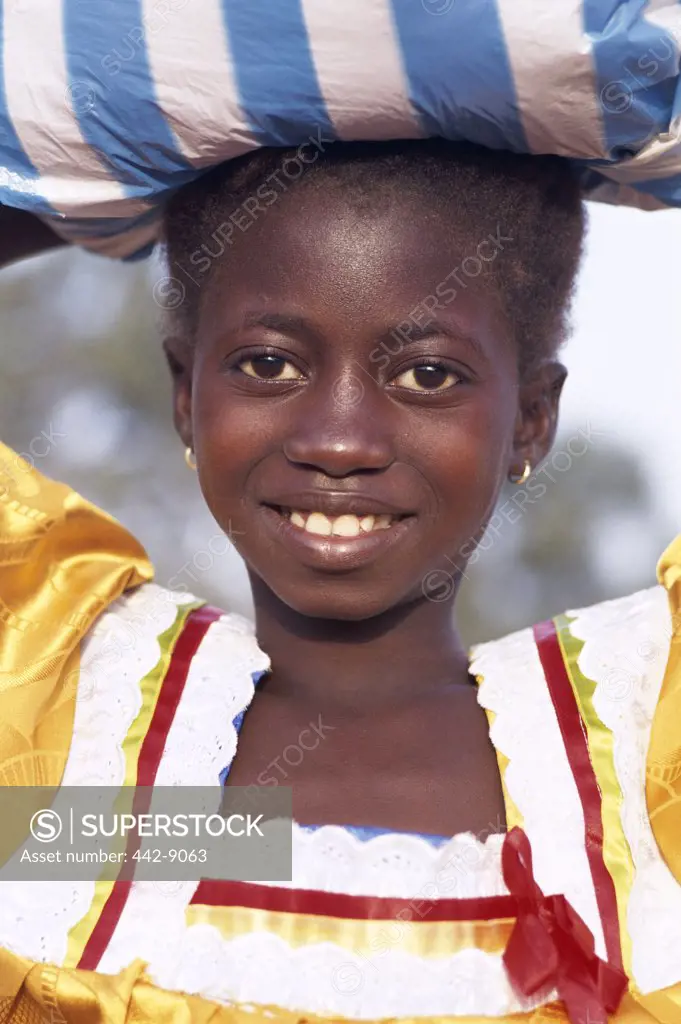 Portrait of an African girl carrying a bundle on her head, Banjul, Gambia
