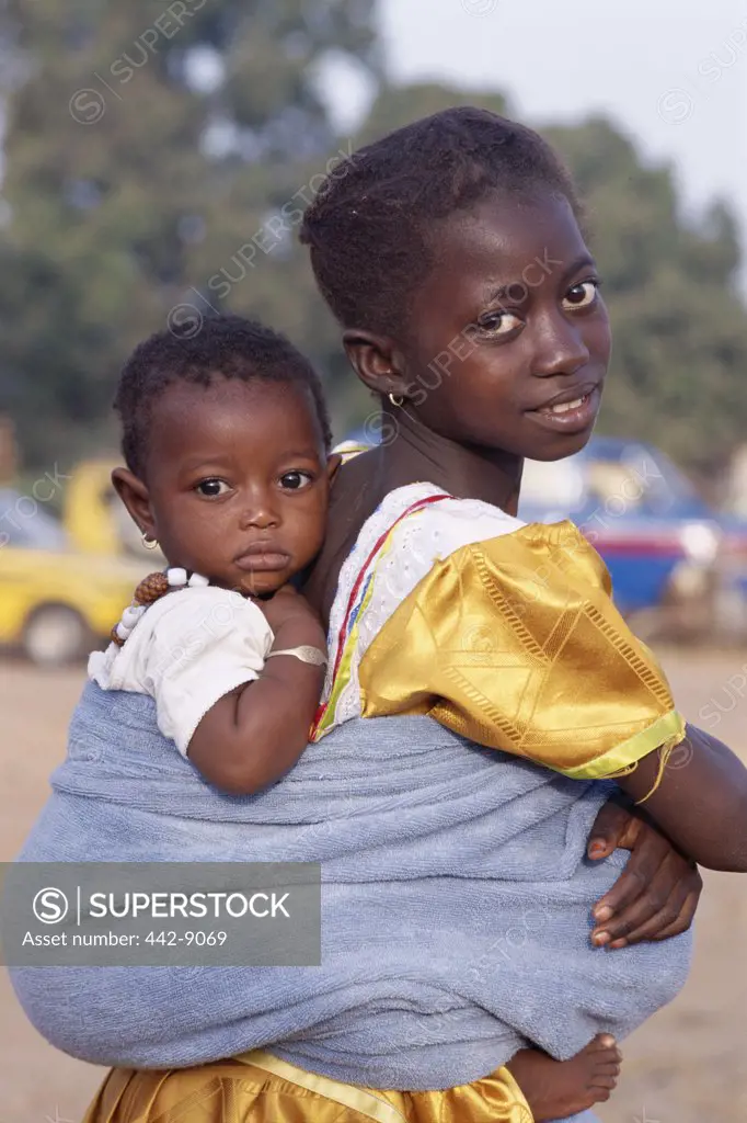 Portrait of an African girl carrying a baby on her back, Banjul, Gambia